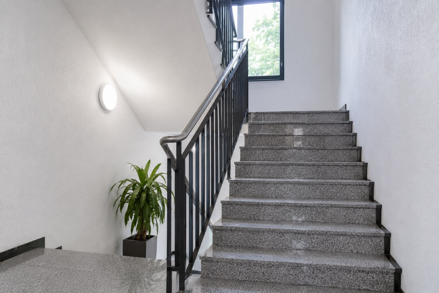 Sauberes Treppenhaus mit Mopp im Vordergrund